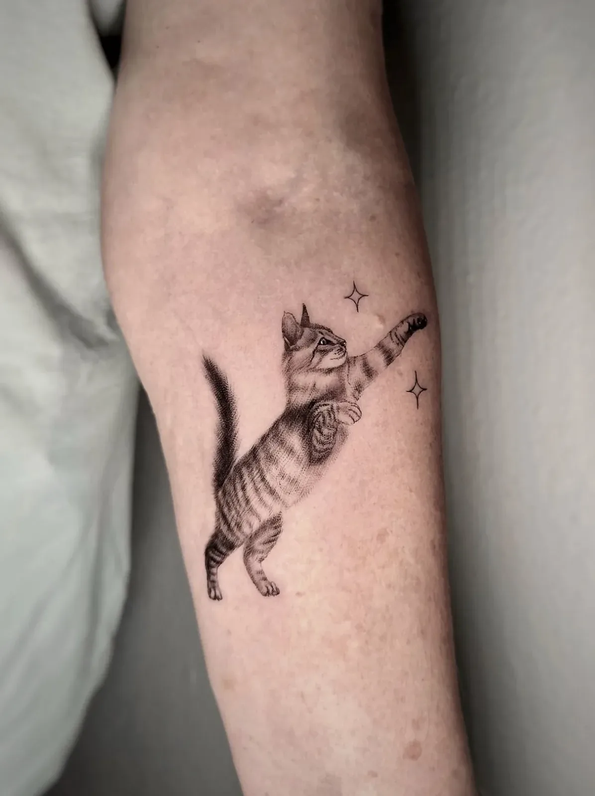 Eine verspielte Katze, Tattoo am Unterarm von Eveline