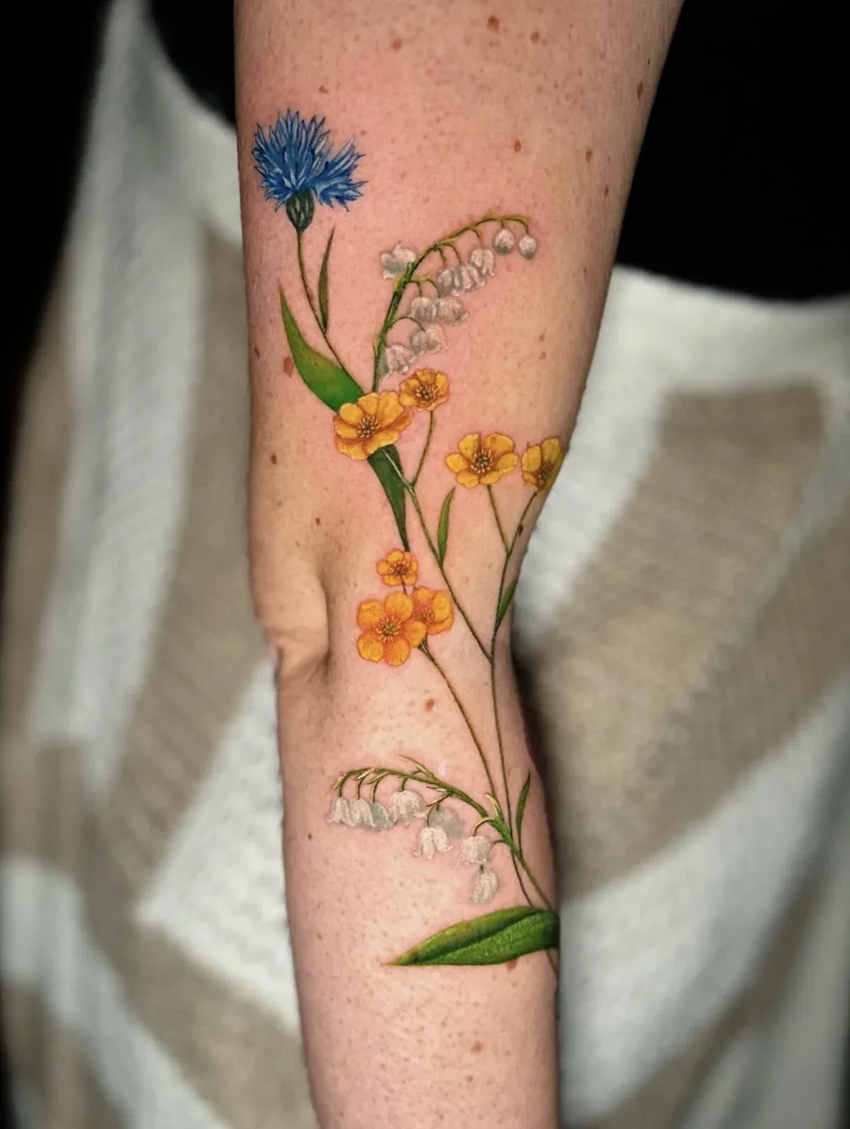 Wildblumen in Farbe, Tattoo am Arm von Eveline