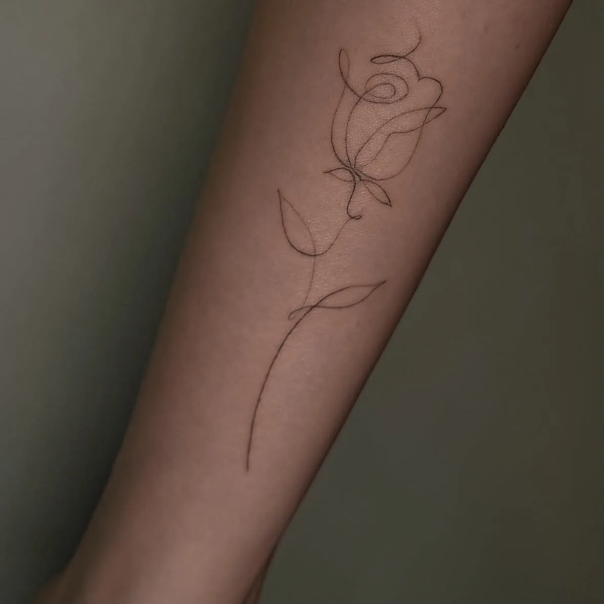 Rose aus einer durchgehenden Linie. Fine-Line-Tattoo von Inna auf dem Unterarm.