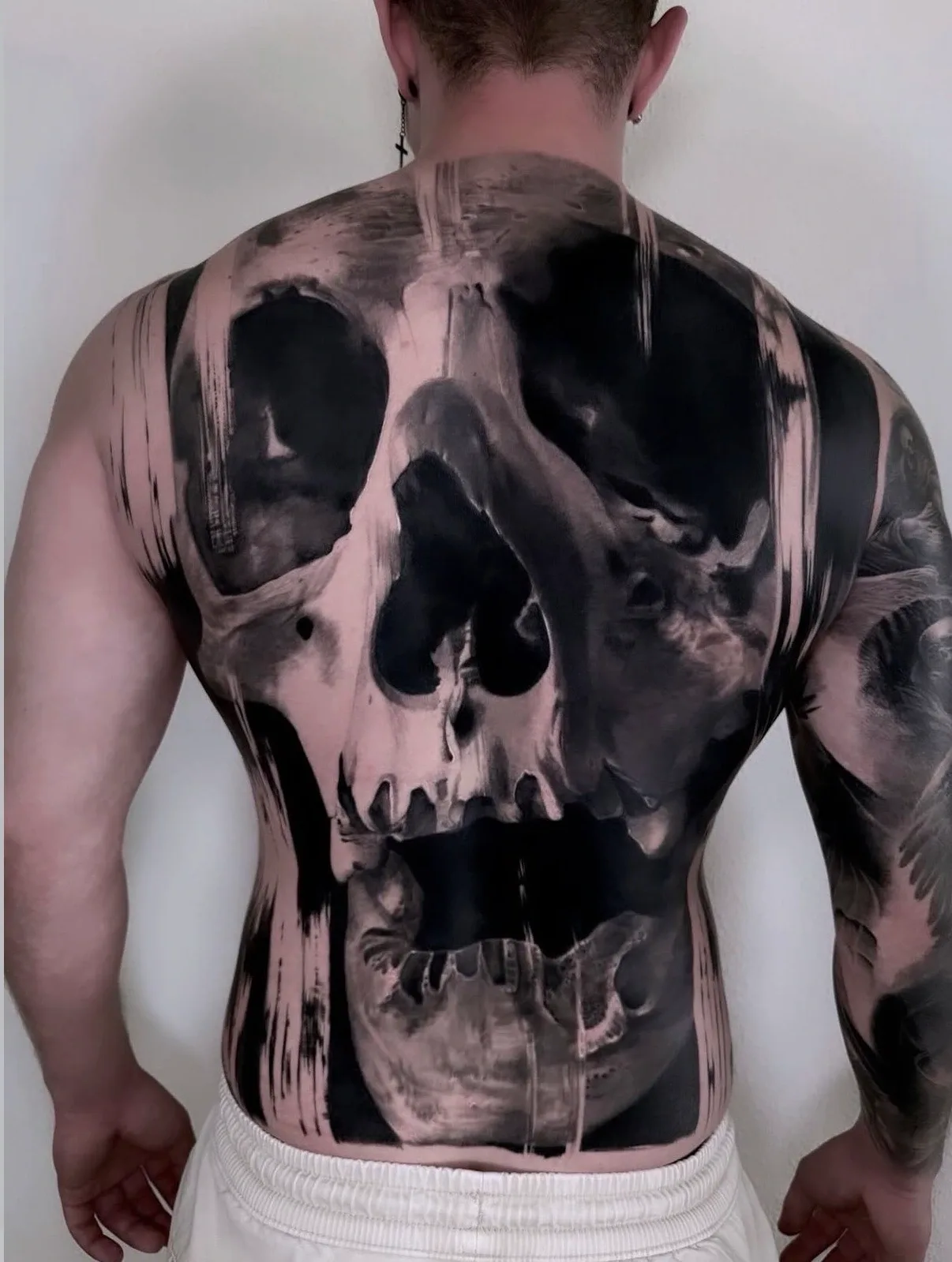 Großflächiges Totenkopf-Tattoo von Ruby über den Rücken mit schwarzen grafischen Flächen
